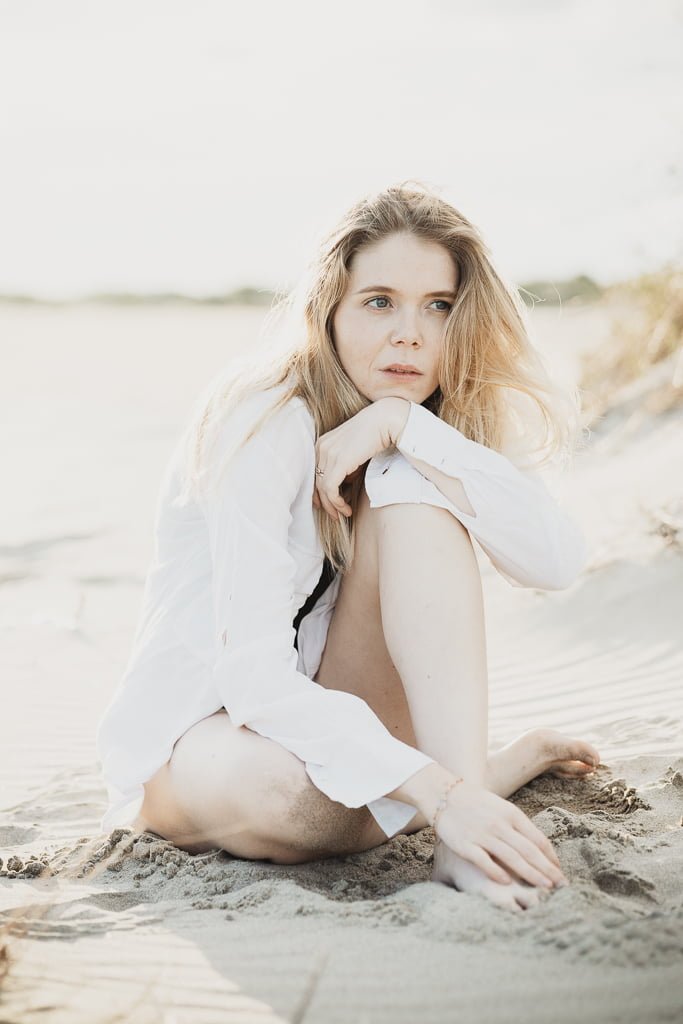 modèle feminin posant assise dans le sable sur une plage en Provence