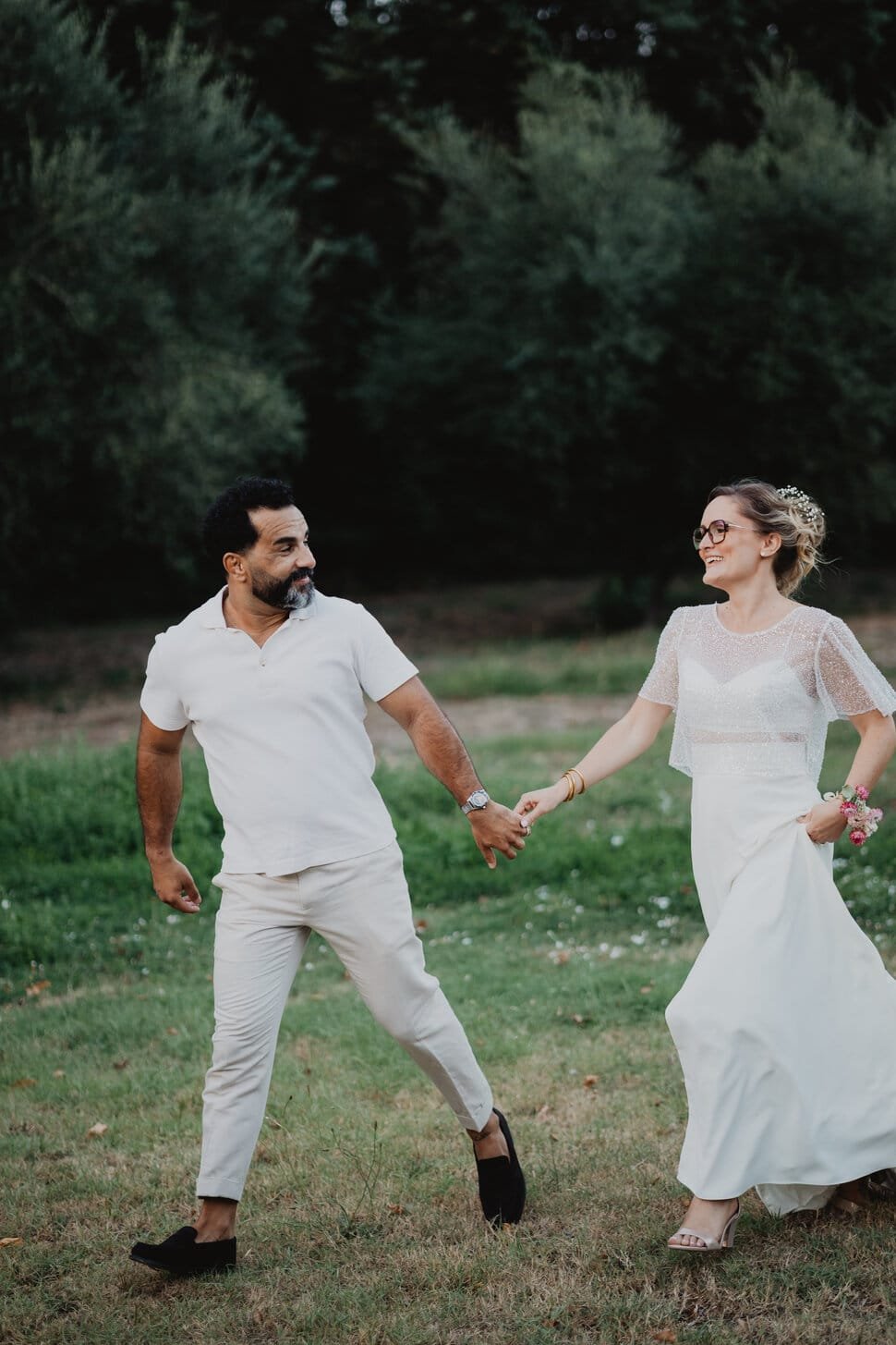 couple mariés se tenant la main dans un jardin provençal.