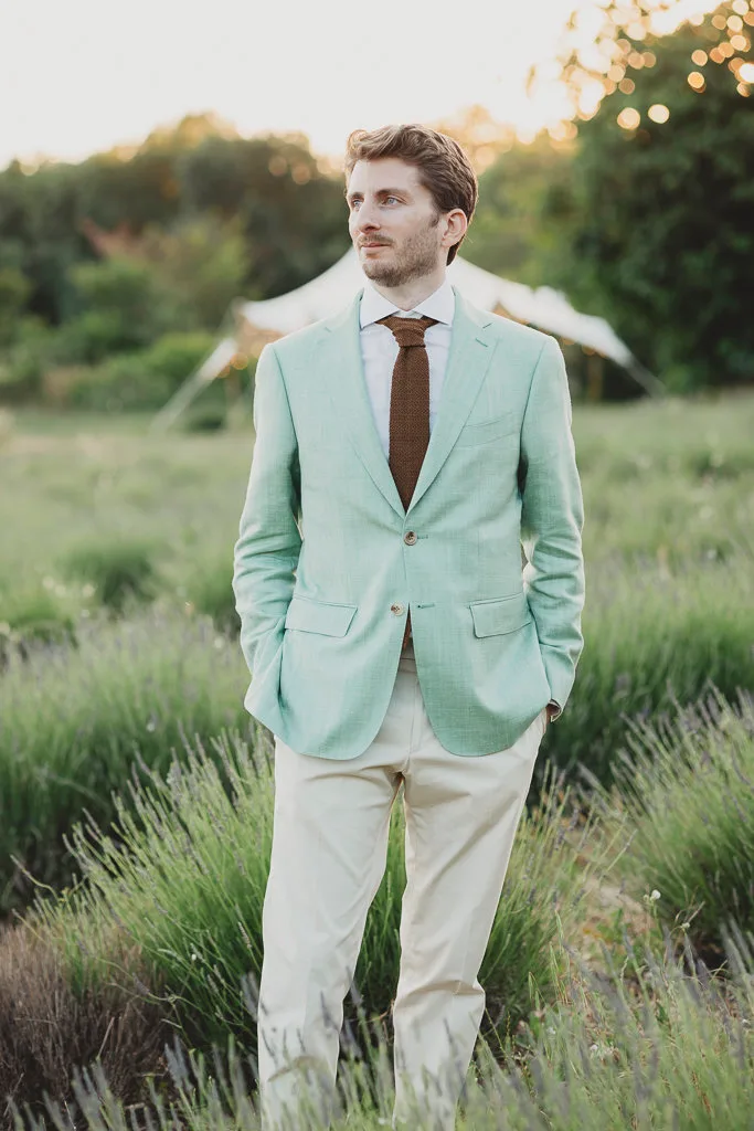 marié en costume vert dans un champ de lavande en Provence